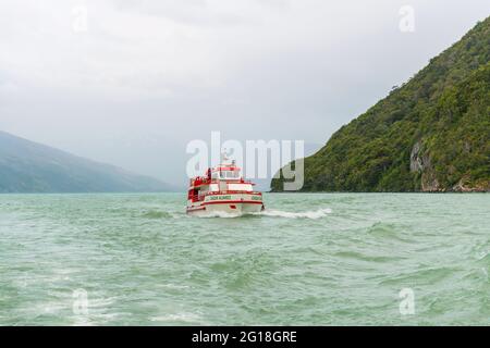 Excursion ferry with tourists sailing in the Last Hope Sound fjord, Bernardo O'Higgins national park, Patagonia, Chile. Stock Photo