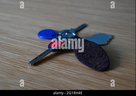 Close-up of a house keys with a keychain on a wooden table. Stock Photo