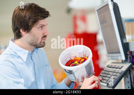 portrait of hardware store worker checking paint in computer Stock Photo