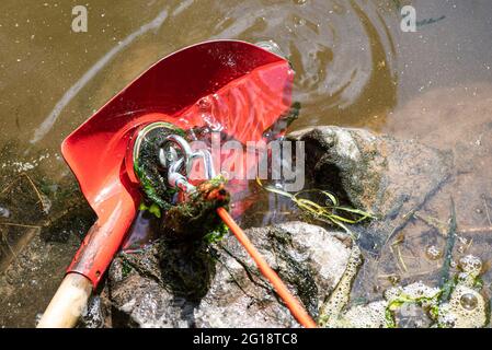 Grebenstein, Germany. 05th June, 2021. ILLUSTRATION - A bucket hangs from a  rope when fishing with a magnet in the Werra. In this special type of  fishing, a magnet is attached to a line or rope and pulled through the  water. In this way, the anglers try to