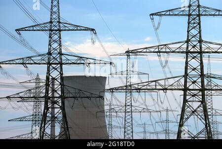 Grafenrheinfeld, Germany. 03rd June, 2021. Masts of a power line stand near a cooling tower of the decommissioned nuclear power plant. Credit: Karl-Josef Hildenbrand/dpa/Alamy Live News Stock Photo