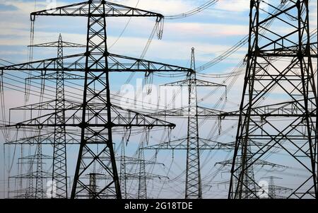 Grafenrheinfeld, Germany. 03rd June, 2021. Masts of a power line stand near the decommissioned nuclear power plant. Credit: Karl-Josef Hildenbrand/dpa/Alamy Live News Stock Photo