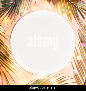 Minimal summer concept with palm tree leaf. Creative copyspace with paper frame. Creative layout made of colorful tropical leaves on white background. Stock Photo