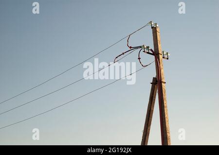 Old wooden electricity pylon view against the sky Stock Photo