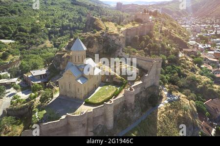 Orthodox church in Tbilisi with fort wall aerial drone view on sunny light Stock Photo