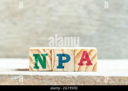 Alphabet letter block in word NPA (Abbreviation of Non performing assets or Nasopharyngeal airway) on wood background Stock Photo