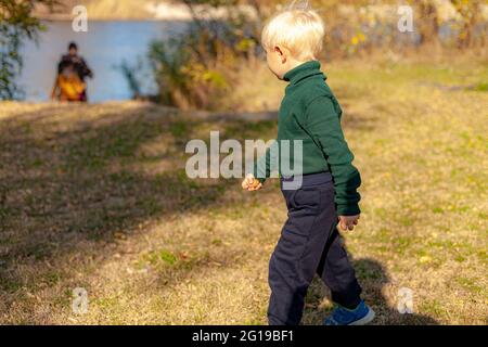 A little boy that is standing in the grass Stock Photo