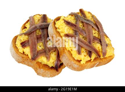 Scotch woodcock lightly scrambled eggs on toast topped with anchovy fillets an old traditional British meal isolated on a white background Stock Photo
