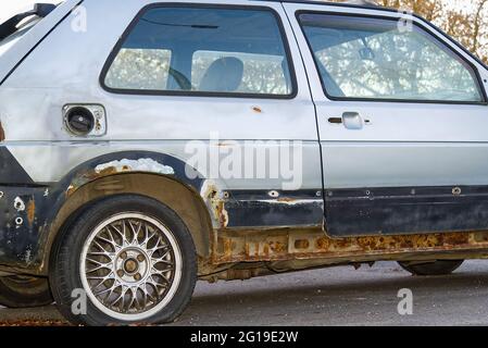 old broken rusty car on flat tires, junk car Stock Photo