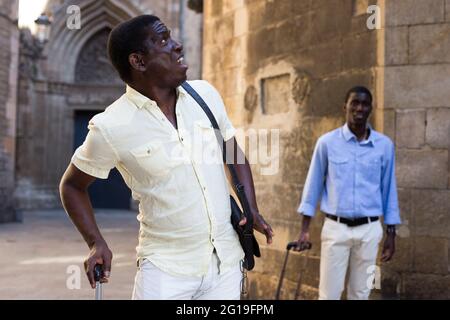 Emotional african american traveler walking through city Stock Photo