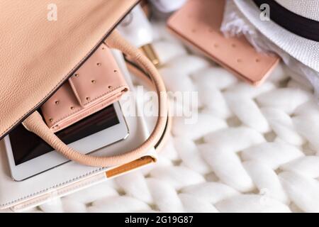 Top view composition organization storage of female handbag lying on white knitted plaid close up Stock Photo