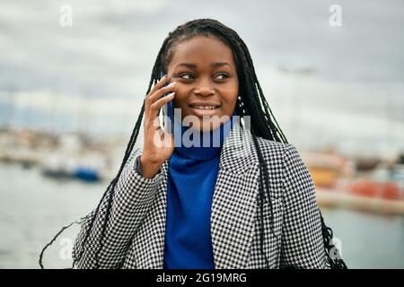 Young african american businesswoman smiling happy talking on the smartphone at the port. Stock Photo