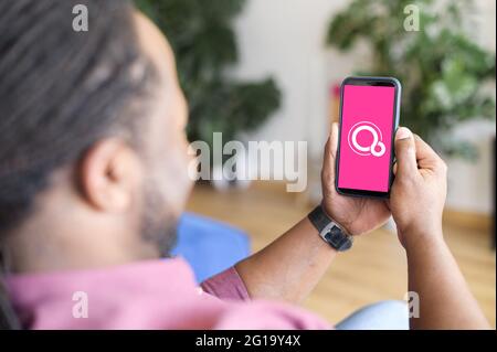 Kyiv, Ukraine - April 28, 2021: Smartphone in male hands with Google Fuchsia OS on the screen Stock Photo