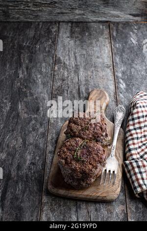 Beef  cutlets on wooden board on rustic wooden table Stock Photo
