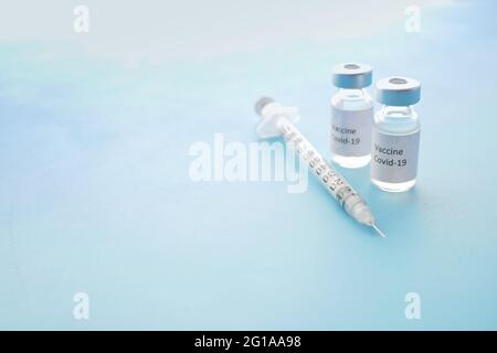 coronavirus vaccine and syringe on blue background Stock Photo
