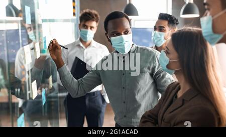 Workers in masks having meeting using sticky adhesive notes Stock Photo