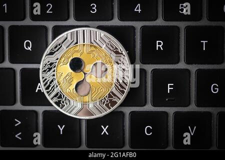 Ripple cryptocurrency physical coin laying on a laptop keyboard. Stock Photo