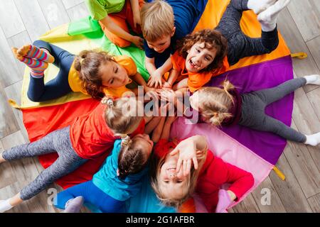 Cheerful children playing team building games on a floor Stock Photo