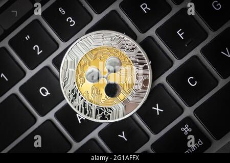 Ripple cryptocurrency physical coin laying on a laptop keyboard. Stock Photo