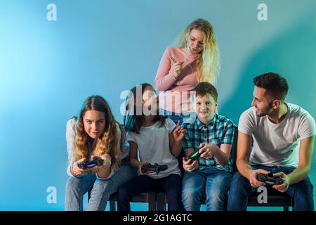 Family holding joysticks and start virtual game Stock Photo