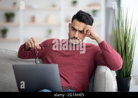 Pensive arab man working on laptop, looking for solution Stock Photo