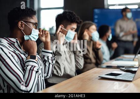International business people wearing medical masks using laptops Stock Photo