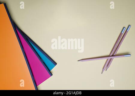 Student flat lay with colorful books and pencils on orange yellow background Stock Photo