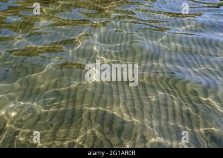 Crystal clear water rippled and sunny reflections Stock Photo