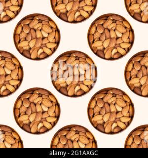Almond nuts in the round wooden bowl repeat seamless pattern on light background. Stock Photo