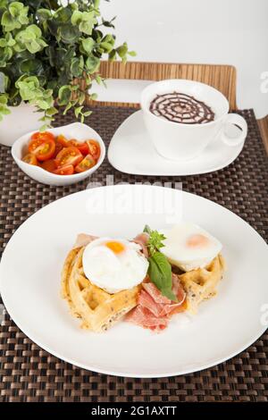 Healthy breakfast; tasty waffles with poached eggs. Stock Photo