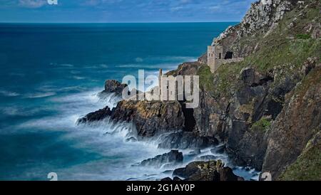 Abandoned Cornish tin mines The Crowns Tin mines Botallack  St.Just Cornwall perched on the edge of the Cornish coast and Atlantic Ocean . Stock Photo