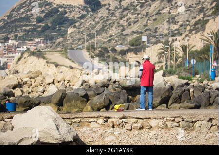 person fishing on the coast of the city of Alicante, in the Valencian Community, Spain. view Stock Photo