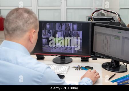 CCTV security system operator monitoring video cameras Stock Photo
