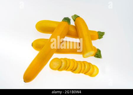 Closeup top view of fresh ripe Yellow Zucchini,Courgette fruits full and  sliced  displayed isolated against white background Stock Photo