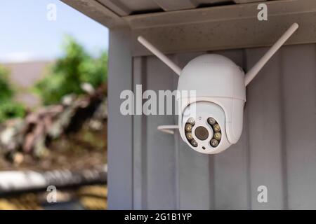 modern CCTV wifi surveillance camera installed on the garage Stock Photo
