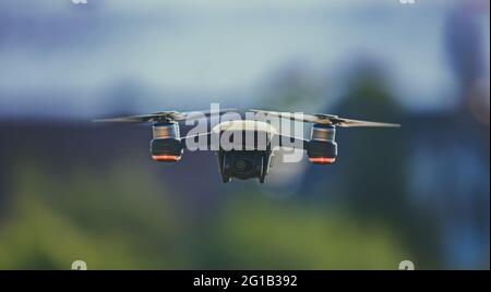 Drone in the air in hovering position with beautiful bokeh effect - unmanned aerial vehicle - airplane - toy - quadcopter - radio remote control. Stock Photo