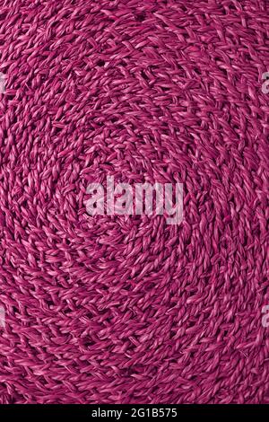 Spiral texture of magenta colored woven water hyacinth place mat Stock Photo