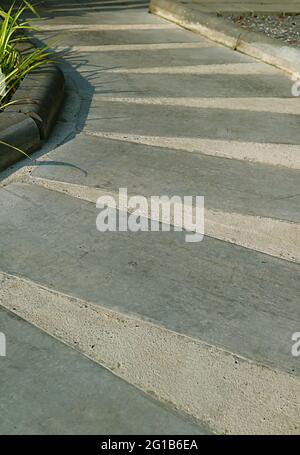 Empty striped curved concrete path in the sunlight Stock Photo