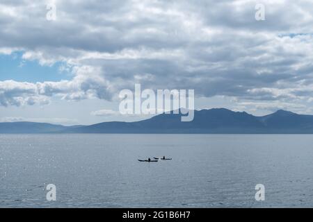 Portencross, Scotland, UK. 6th June 2021. UK Weather: Two canoeists with the Isle of Arran in the background. Credit: Skully/Alamy Live News Stock Photo