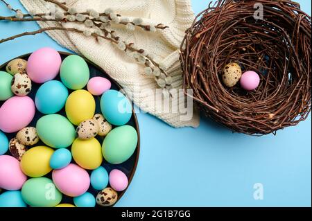 Colorful easter eggs in bowl and decorative nest Stock Photo