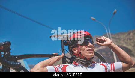 Portrait of young cyclist with his bike on the road. Sport concept, Selective focus Stock Photo