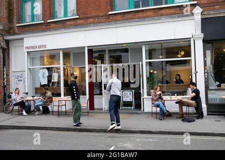 People men queuing social distancing standing outside Prufrock Coffee shop during Covid 19 pandemic in Exmouth Market London England UK KATHY DEWITT Stock Photo