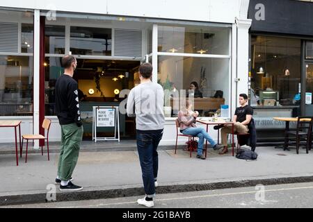 People men queuing social distancing standing outside Prufrock Coffee shop during Covid 19 pandemic in Exmouth Market London England UK KATHY DEWITT Stock Photo