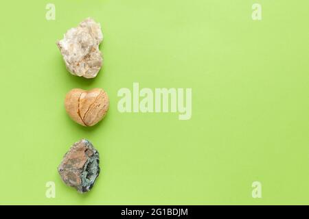 Different minerals and heart stone on green background. Backgrounds and textures, nature concept - rocks and minerals. Stock Photo