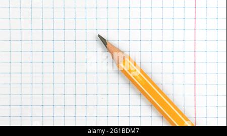 Sharp lead pencil school stationery on a checkered notebook background, close-up with copy space, top view Stock Photo