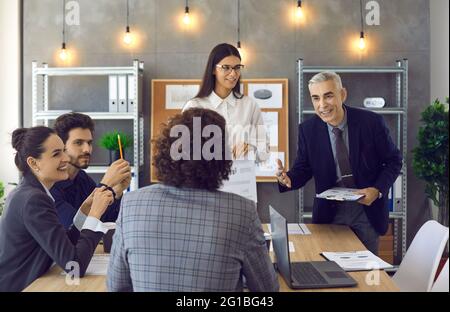 Group of workers giving a presentation to colleagues in a corporate team meeting Stock Photo