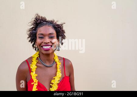 Happy African American female standing near white wall and looking at camera Stock Photo