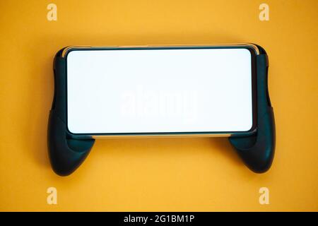 Joystick mobile phone, screen mockup Isolated on yellow background top view Stock Photo