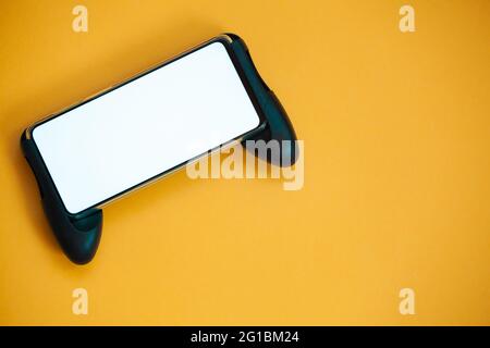 Joystick mobile phone, screen mockup Isolated on yellow background top view Stock Photo