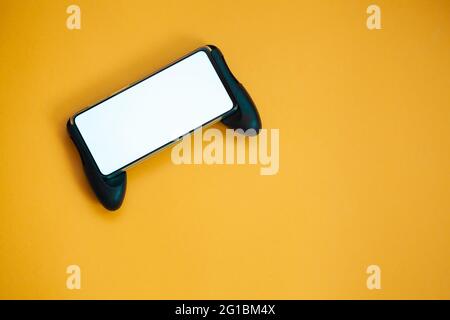 Joystick mobile phone, screen mockup Isolated on yellow background top view Stock Photo